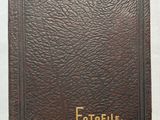 un livre marron orné de lettres dorées, posé sur une surface blanche