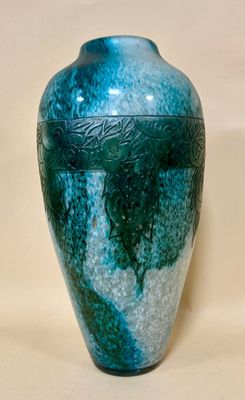 a blue and green vase sitting on a white surface