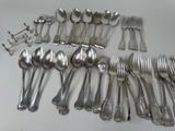 a lot of spoons and forks laid out on the table