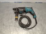 a corded drill with a cord attached to it on a metal surface