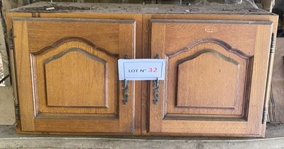 une armoire en bois sur laquelle est accrochée une pancarte, au milieu d'une pièce