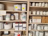 many cans of paint on the shelves in the room