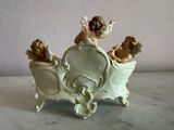 porcelain figurine of two cherensils in a carriage with a mirror