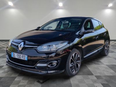 Une voiture noire est garée dans une grande pièce au sol carrelé.