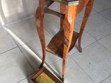 une petite table en bois avec un plateau en marbre, posée sur un sol carrelé