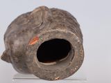 a small vase with a hole in it on a stand