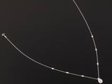 a close up of a necklace on a black surface with a black background
