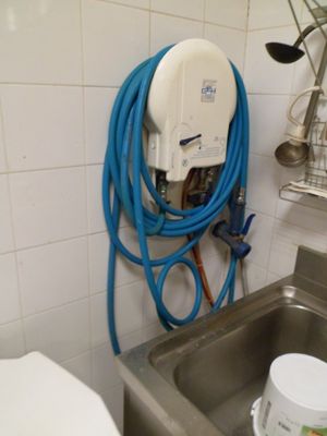 un tuyau bleu fixé au mur à côté d'un évier