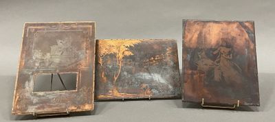 Trois vieux livres sont posés sur une table devant un fond gris.