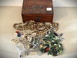 une petite boîte en bois sur laquelle sont disposés plusieurs bijoux