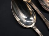 three spoons that are sitting on a table