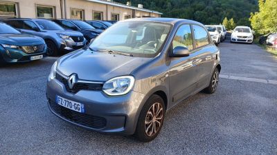 une voiture grise garée sur un parking, avec d'autres voitures en arrière-plan
