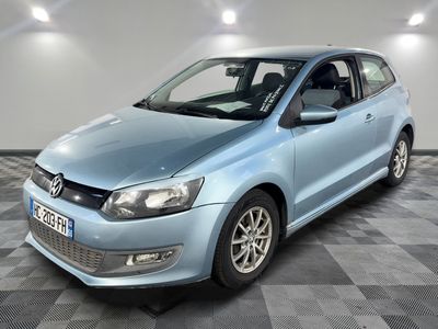 La Volkswagen Polo bleue est garée dans une pièce au sol carrelé en damier.