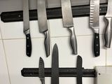 many knives hanging on the wall in the kitchen