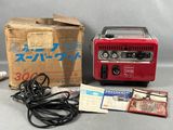 une photo d'un générateur portable rouge posé sur une caisse