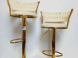 pair of gold metal bar stools with white upholstered seats