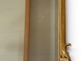 a mirror with a gold frame on the wall
