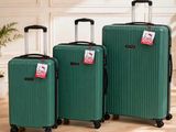 trois bagages posés sur un parquet, à côté d'une plante