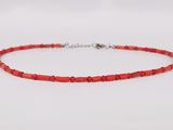 a red beaded necklace on a white background