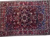 un tapis rouge et bleu orné d'un motif en médaillon sur fond blanc