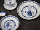 several blue and white plates and spoons on a table
