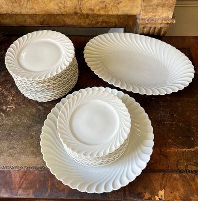 four white plates and bowls on a wooden table