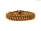 gros plan d'un bracelet en or sur fond blanc