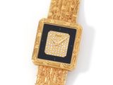 a close up of a gold wrist watch with a black face