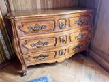 une commode en bois dans une pièce où il y a un tapis au sol