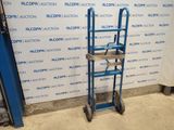 an image of a blue hand truck in front of a wall