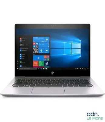 the laptop is open on a white surface with windows on the screen