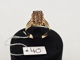 un gros plan d'une bague en or posée sur un présentoir noir