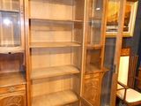 a tall wooden cabinet with a glass door in a room