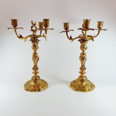 pair of antique brass candelabs with flowers on each of them