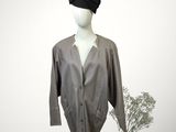 grey shirt on a mannequin stand with a flower in a vase
