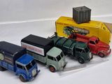 several toy trucks are lined up next to each other on a white surface