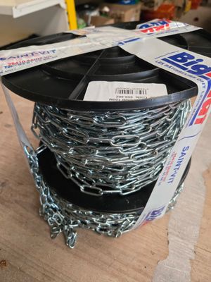une bobine de chaîne posée sur la table, à côté d'une boîte