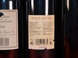 three bottles of wine are lined up on a shelf