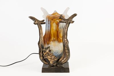 un vase posé sur une table, auquel est attaché un cordon