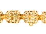 gros plan d'un bracelet en or sur fond blanc