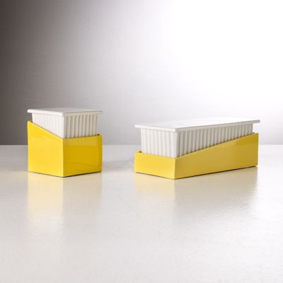 deux récipients jaunes et blancs posés sur une table blanche