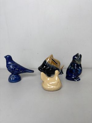 trois petites figurines d'oiseaux posées sur une table