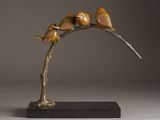 sculpture of three birds perched on a branch on a gray background