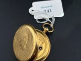 a close up of a gold pocket watch on a black surface