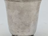 an antique silver cup on a pedestal on a white background