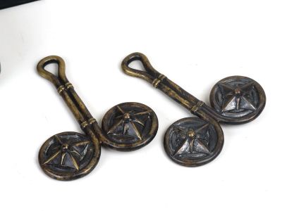 three antique brass plated buttons on a white surface next to a computer keyboard