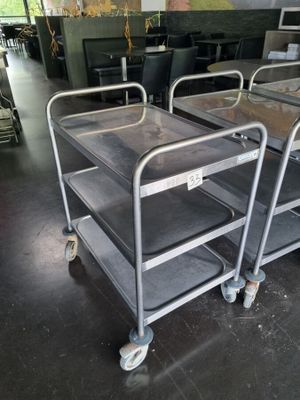 three metal trolleys are sitting in a room with a painting on the wall