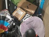 a cardboard box filled with skis, snowboards, and other items