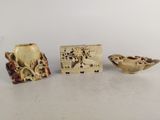 trois objets sculptés en ivoire et en bois sont posés sur une table