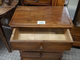 a small wooden table with a drawer on top of it